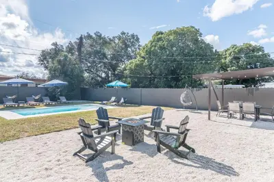a patio with chairs and a table and a pool at Near Beach Family Escape Heated Pool Fire Pit BBQ in Hallandale Beach