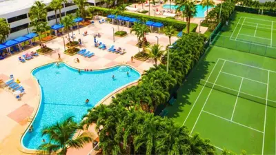 an overhead view of a pool with a tennis court at Beachfront Oasis in Sunny Isles 3BR, Pool & Tennis in Sunny Isles Beach