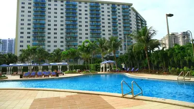 a swimming pool in front of a large building at Beachfront Oasis in Sunny Isles 3BR, Pool & Tennis in Sunny Isles Beach