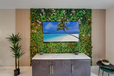 a wall with a picture of a palm tree on a beach at Beachfront Oasis in Sunny Isles 3BR, Pool & Tennis in Sunny Isles Beach