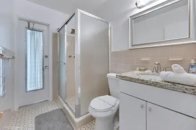 a bathroom with a toilet and a sink and a mirror at Tropical 3BR Escape with Pool, 7 Min Drive to Beach in Hollywood