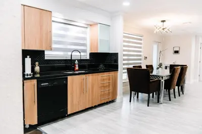 a kitchen with a sink and a table with chairs at Welcome to 305 Rentals in Miami Gardens