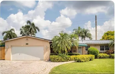 a house with a garage and palm trees at Gardens Get Away in Pembroke Pines