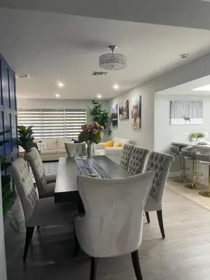 a dining table and chairs in a living room at Gardens Get Away in Pembroke Pines