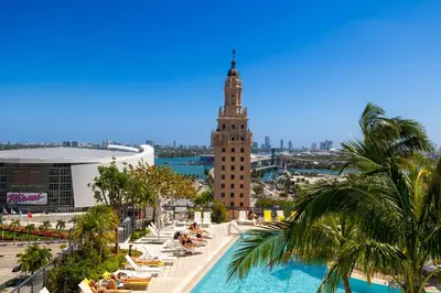 a view of a building with a pool and a clock tower at Phenomenal 1 Bed - Amazing views in Miami