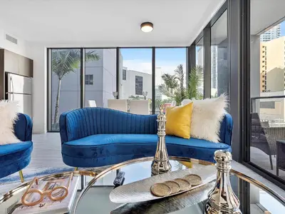 a living room with blue couches and a glass table at X Lounge III-Modern Corner Residence in Miami