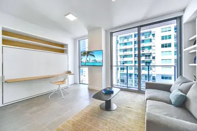 a living room with a couch and a large window at Great Miami Stay Steps from Bayside & the Beach in Miami