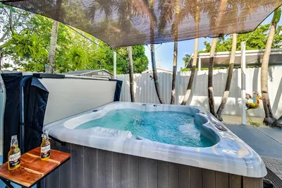 a hot tub with two bottles of beer in it at Luxurious Tropical Private Oasis by Mia Airport in Hialeah