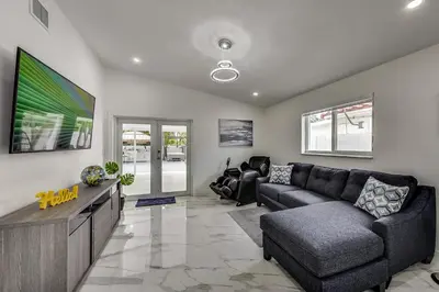 a living room with a couch and a flat screen tv at Luxurious Tropical Private Oasis by Mia Airport in Hialeah
