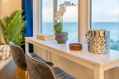 a table with chairs and a window with the ocean at Stunning Beachfront condo in sunny Sunny Isles Beach with AC, fitness room, WiFi in Sunny Isles Beach