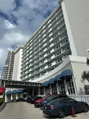 a large building with cars parked in a parking lot at Stunning Beachfront condo in sunny Sunny Isles Beach with AC, fitness room, WiFi in Sunny Isles Beach