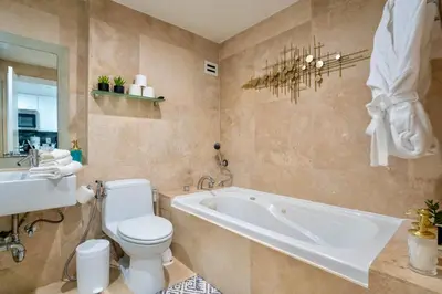 a bathroom with a tub and a toilet and a sink at Stunning Beachfront condo in sunny Sunny Isles Beach with AC, fitness room, WiFi in Sunny Isles Beach