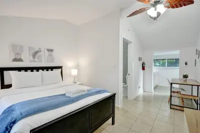 a bedroom with a large bed and a ceiling fan at Tropical Oasis Studio w Pool in Fort Lauderdale