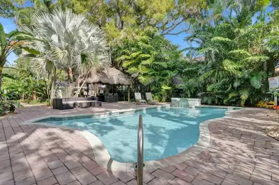 a swimming pool in the middle of a yard with trees at Tropical Oasis Studio w Pool in Fort Lauderdale