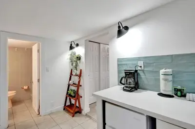 a kitchen with a white counter and a blue wall at Tropical Oasis Studio w Pool in Fort Lauderdale