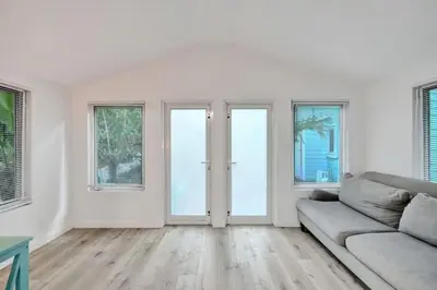 a white living room with a couch and windows at Tropical Oasis 2BR w Pool in Fort Lauderdale