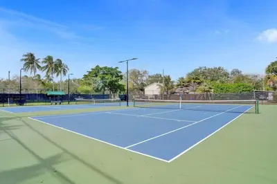 a tennis court with two tennis courts at Tropical Oasis 2BR w Pool in Fort Lauderdale