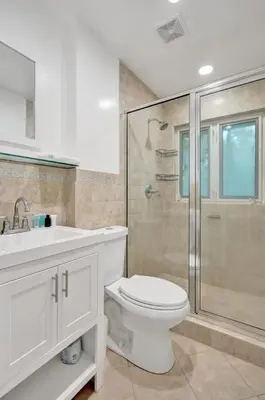 a white bathroom with a toilet and a shower at Tropical Oasis Studio w Pool in Fort Lauderdale