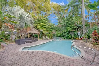 a swimming pool with a brick walkway around it at Tropical Oasis 2BR House w Pool in Fort Lauderdale
