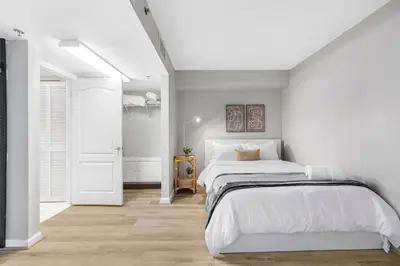 a white bedroom with two beds and a hallway at Enjoy of Beautiful City Views From This Condo in Miami