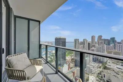 a balcony with a chair and a view of the city at On 47th Floor! Free Parking & Views From The Top in Miami