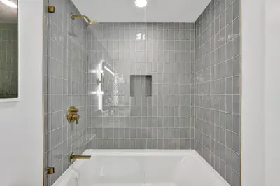 a bath tub in a bathroom with gray tiles at On 47th Floor! Free Parking & Views From The Top in Miami