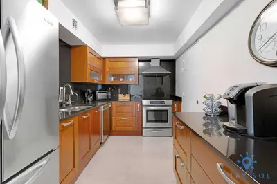 a kitchen with wooden cabinets and stainless steel appliances at Stylish Ocean Apartment with Pool in Hollywood