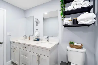 a white bathroom with a sink and a mirror at Las Olas Fort Lauderdale Getaway Pool, BBQ, Mini Golf & Game Room in Fort Lauderdale