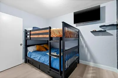 a bedroom with a bunk bed and a tv at Las Olas Fort Lauderdale Getaway Pool, BBQ, Mini Golf & Game Room in Fort Lauderdale