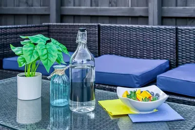 a bottle of water and a bowl of vegetables on a table at Las Olas Fort Lauderdale Getaway Pool, BBQ, Mini Golf & Game Room in Fort Lauderdale
