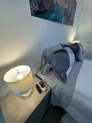 a bedroom with a bed with a table with a lamp at Modern Apartment Miami Oasis in Miami