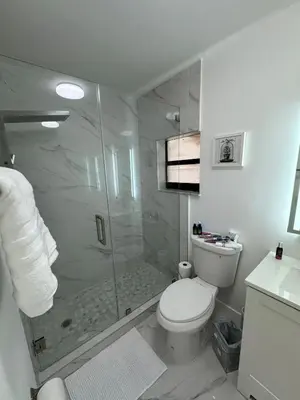 a white bathroom with a shower and a toilet at Modern Apartment Miami Oasis in Miami