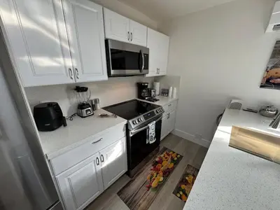 a kitchen with white cabinets and a stove top oven at Modern Apartment Miami Oasis in Miami