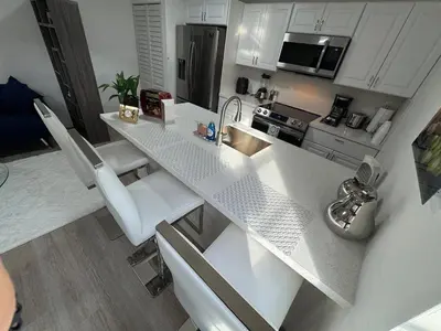 a kitchen with a large white counter top with white cabinets at Modern Apartment Miami Oasis in Miami