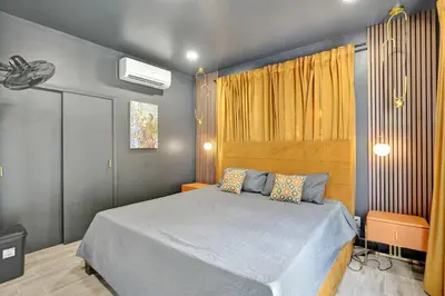 a bedroom with a bed in a room with yellow curtains at Kiki 4 - Men's Clothing optional Guest Houses in Fort Lauderdale