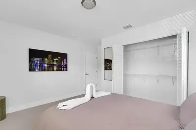 a white bedroom with a white bed and a painting on the wall at Fab 4BR Twin Villas Near Design District and Wynwood in Miami