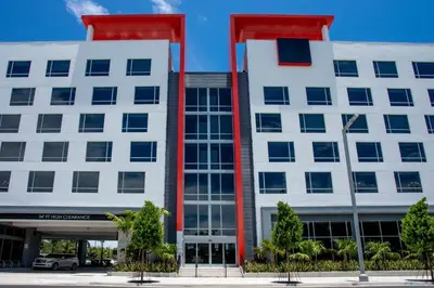 a white building with red columns at Kompose Boutique Miami Airport in Miami