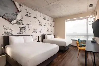 a hotel room with two beds and a desk with a desk at Kompose Boutique Miami Airport in Miami