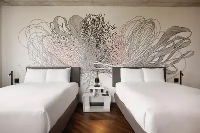 a bedroom with two beds and a wall mural at Kompose Boutique Miami Airport in Miami