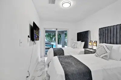 two beds in a hotel room with white walls at Waterfront House - Solar Heated Pool, Arcade Games in Fort Lauderdale