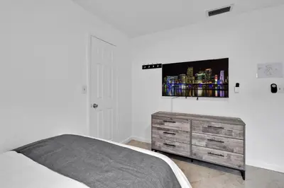 a bedroom with a bed and a tv on the wall at Waterfront House - Solar Heated Pool, Arcade Games in Fort Lauderdale