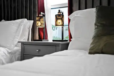 a bed with white sheets and pillows next to a window at Waterfront House - Solar Heated Pool, Arcade Games in Fort Lauderdale