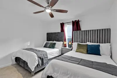 a bedroom with two beds and a ceiling fan at Waterfront House - Solar Heated Pool, Arcade Games in Fort Lauderdale