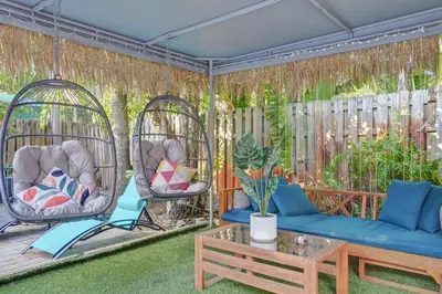 a patio with two swing chairs and a blue couch at Kiki 5 - Men's Clothing optional Guest Houses in Fort Lauderdale