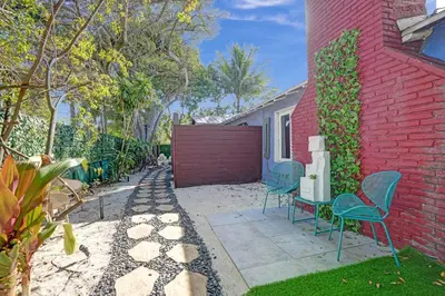 a yard with chairs and a red brick building at Kiki 5 - Men's Clothing optional Guest Houses in Fort Lauderdale