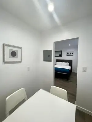a white room with a bed and a table and chairs at Tranquil Studio W Parking 10 min to Beach FLL in Hollywood