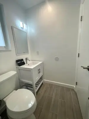 a white bathroom with a toilet and a sink at Tranquil Studio W Parking 10 min to Beach FLL in Hollywood