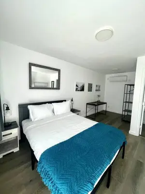 a bedroom with a large bed with a blue blanket at Modern Studio W Parking 10 min to FLL and Beach in Hollywood