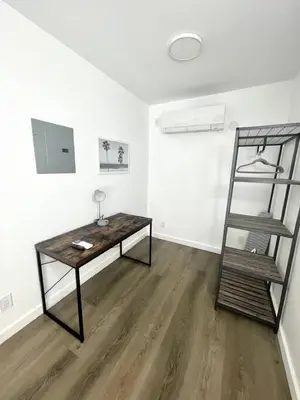 a room with a table and a shelf in it at Modern Studio W Parking 10 min to FLL and Beach in Hollywood