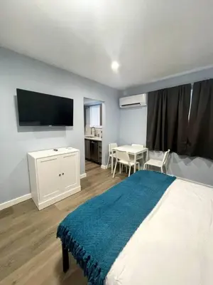 a bedroom with a large bed with a tv on the wall at Las Olas Studio W Parking 10 min to FLL and beach in Hollywood